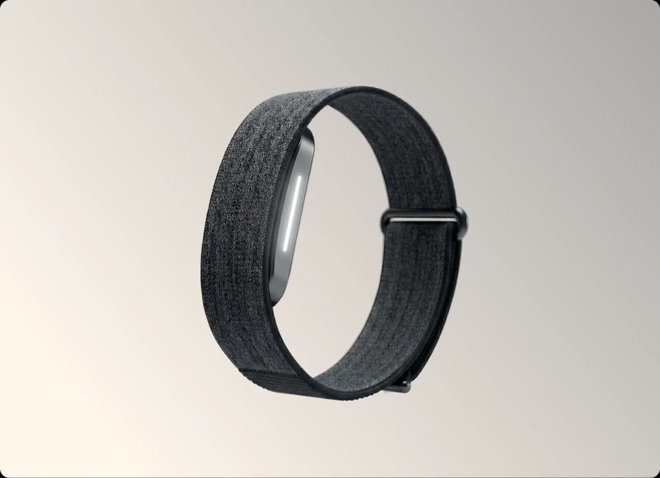 Hume Band 2.0 health tracker with dark fabric strap on a neutral background