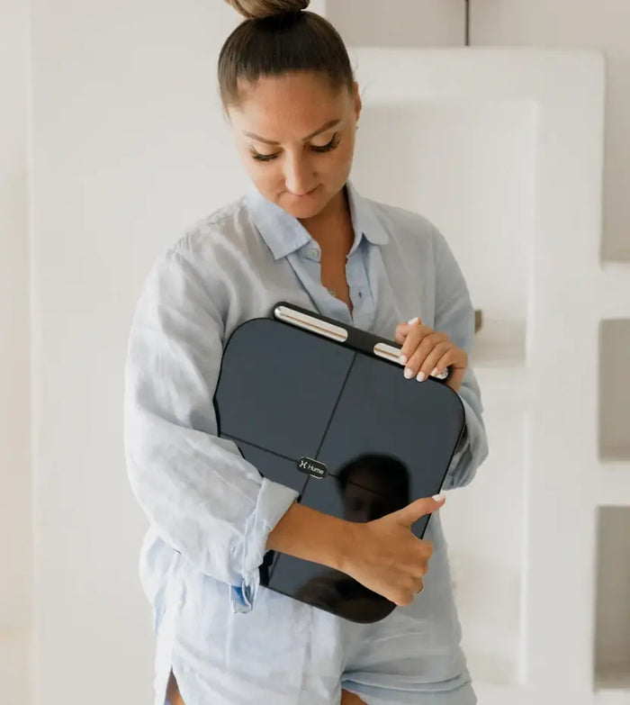 Woman holding the Hume Body Pod scale at home
